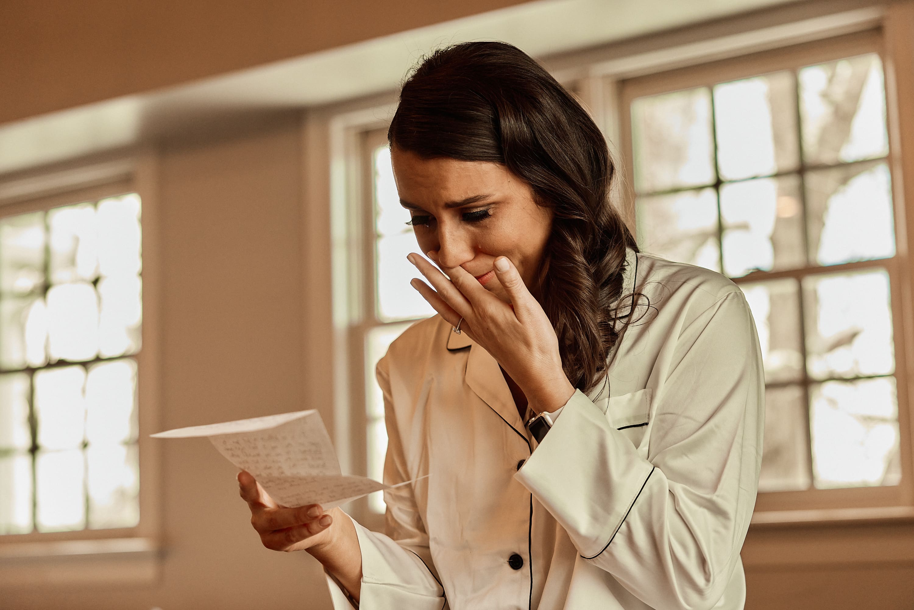 Emotional candid photo of a woman reading a letter on her wedding day